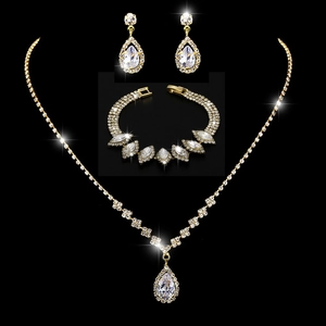 Close-up of sparkling golden teardrop necklace and earring set with crystal rhinestones