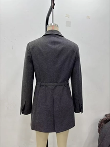 Détail du dos d'un blazer gris foncé ceinturé avec fente structurelle et texture en laine mélangée