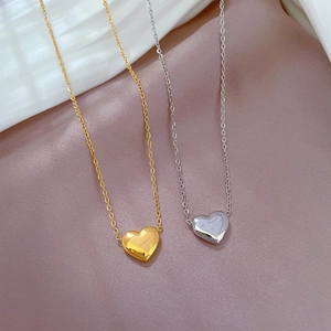 Colliers pendentifs coeur minimalistes en or et argent sur fond de satin doux