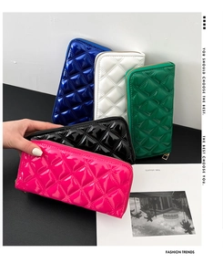 Close-up of assorted glossy patent leather wallets featuring a classic quilted stitch pattern