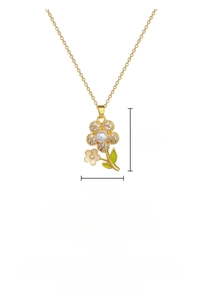 Detail of gold floral necklace with pearls, zircons and green enamel leaf accent