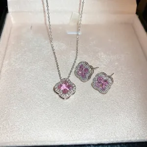 Elegant silver necklace and earrings set with pink clover zircon in a velvet jewelry box