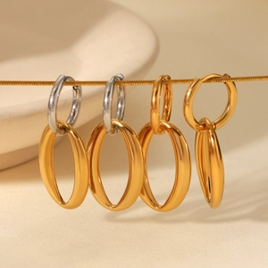 Detailed view of minimalist oval hoop earrings in gold and silver hanging on a line