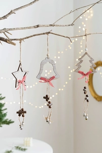 Detail of wooden Christmas ornaments featuring star, bell, and tree shapes with red bows