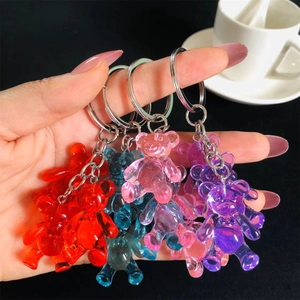 Colorful resin gummy bear keychains held by hand in multiple vibrant jelly colors