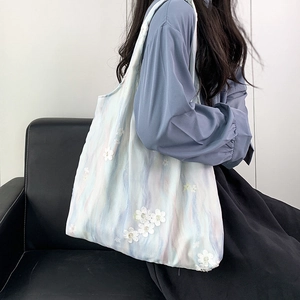 Détail de fleurs en dentelle 3D et motif marbre bleu sur sac fourre-tout en toile