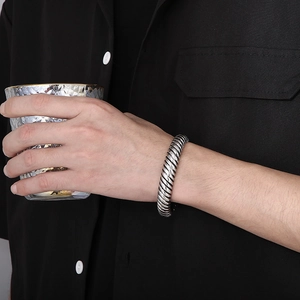 Detail of vintage silver dragon scale twisted cuff bracelet on male model wrist