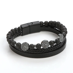 Dettaglio di un bracciale in pelle da uomo con perle di lava nera e ciondoli Albero della Vita