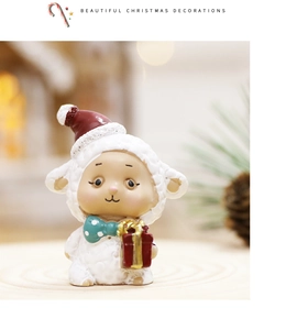 Close-up of cute Christmas sheep figurine in cream white with red hat and gift box