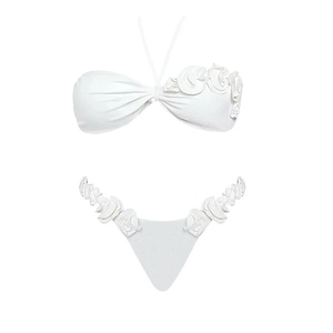 Detail view of 3D floral accents on a white two-piece halter bikini swimwear set