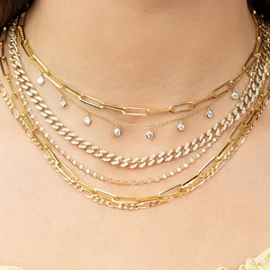 Detail of layered gold-tone S925 silver necklaces with zircon stones on model