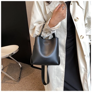 Detail shot of a black bucket bag with Maconee logo and adjustable shoulder strap