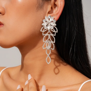 Detailed shot of long silver floral tassel earrings with rhinestones on a model