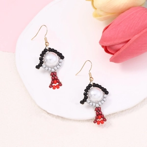 Detail of handmade beaded earrings with cartoon charms and elegant gold hooks