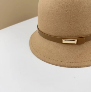 Detail of dark beige wool bucket hat featuring brown leather strap and golden buckle