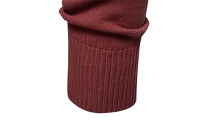 Close-up of ribbed cuffs on a dark red knit sweater showing detailed texture and stitching