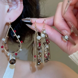 Close-up of vintage crystal chain tassel earrings with colorful beads on female model