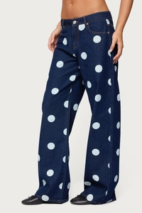 Detail view of wide-leg dark blue jeans with white polka dots on a standing model