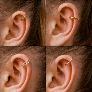 Detail view of four gold-plated U-shaped ear cuffs with textured and layered designs
