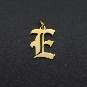 Detailed view of a vintage gold hollow alphabet E pendant for DIY jewelry making
