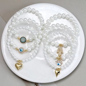 Adjustable woven pearl bracelets with gold Evil Eye and Hamsa Hand charms for women