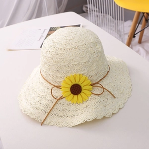 Detail of crochet straw sun hat with yellow sunflower decor and wavy brim design
