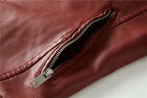 Detail of burgundy leather jacket with silver metal zipper pocket and stitching