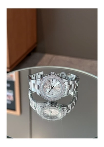 Detailed close-up of a silver ladies watch with a rhinestone-studded bezel and steel band
