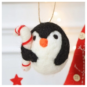 Handmade wool felt penguin ornament with a candy cane for Christmas tree decor