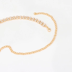 Close-up of golden metal chain belt featuring double-row rectangle rhinestones