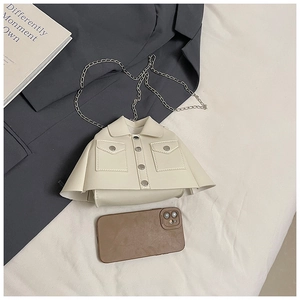 Close-up of cream mini bag with unique jacket design details and silver chain strap