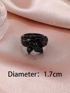 Gothic black skull flower ring detail with 1.7cm diameter measurement on pink silk