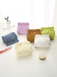 Detail view of multi-color corduroy mini pouches with squeeze closure and ribbed texture