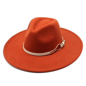 Detailed top view of a brick orange wide brim wool fedora with a white leather band decoration