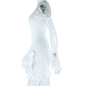 Detail of white bodycon dress with 3D fabric rose accents and ruffled hemline