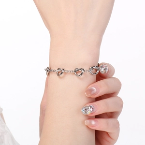 Bracelet à nœuds argenté au poignet montrant le design élégant et minimaliste en acier