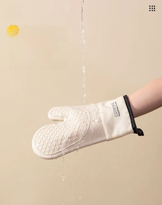 Waterproof silicone oven mitt being washed under water to show easy-clean surface