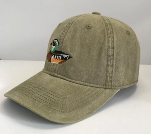 Detail of vintage khaki baseball cap with colorful duck embroidery and washed cotton texture