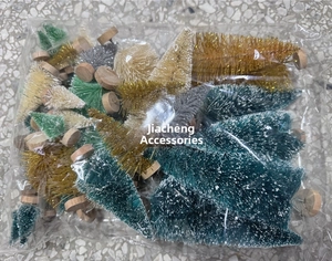 Macro view of multi-color mini bottle brush Christmas trees with snowy tips and wood bases