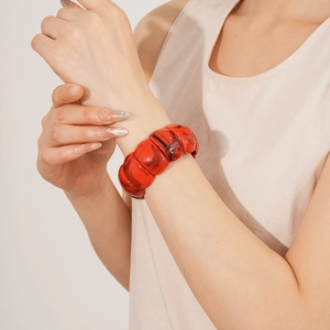 Detailed close-up of red marble pattern acrylic modular elastic cuff bracelet on wrist