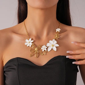 Detail of flower necklace with white enamel petals and hollow gold metal pendants