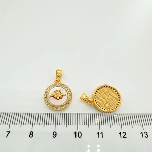 Detail showing gold shell pendant size with bee pattern and cubic zirconia inlay