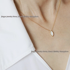 Detail of a vintage 18K gold plated titanium necklace with white shell pendant on a neck