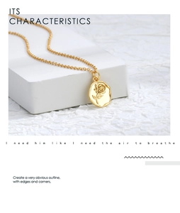 Detail view of a gold-plated rose flower relief on a round coin pendant necklace