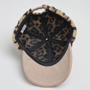 Detail view of winter baseball cap featuring corduroy brim and leopard faux fur lining