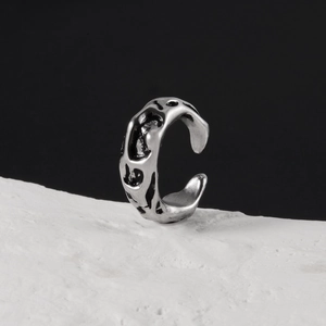 Vue macro de la texture de lave argentée sur un earcuff ajustable aux détails vintage noirs