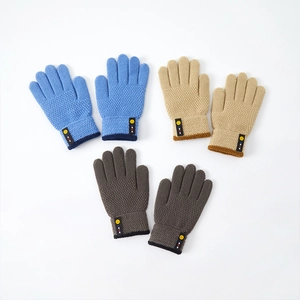 Three pairs of knit gloves for kids in blue, beige, and brown with smiley face labels