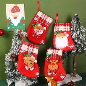 Festive red felt Christmas stockings with 3D Santa and snowman characters on a green wall