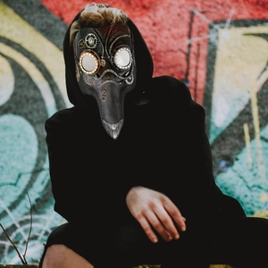 Maschera da medico della peste steampunk con ingranaggi metallici su sfondo graffiti