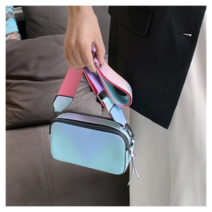 Detail of gradient pink-blue camera bag with wide shoulder strap and dual zipper finish